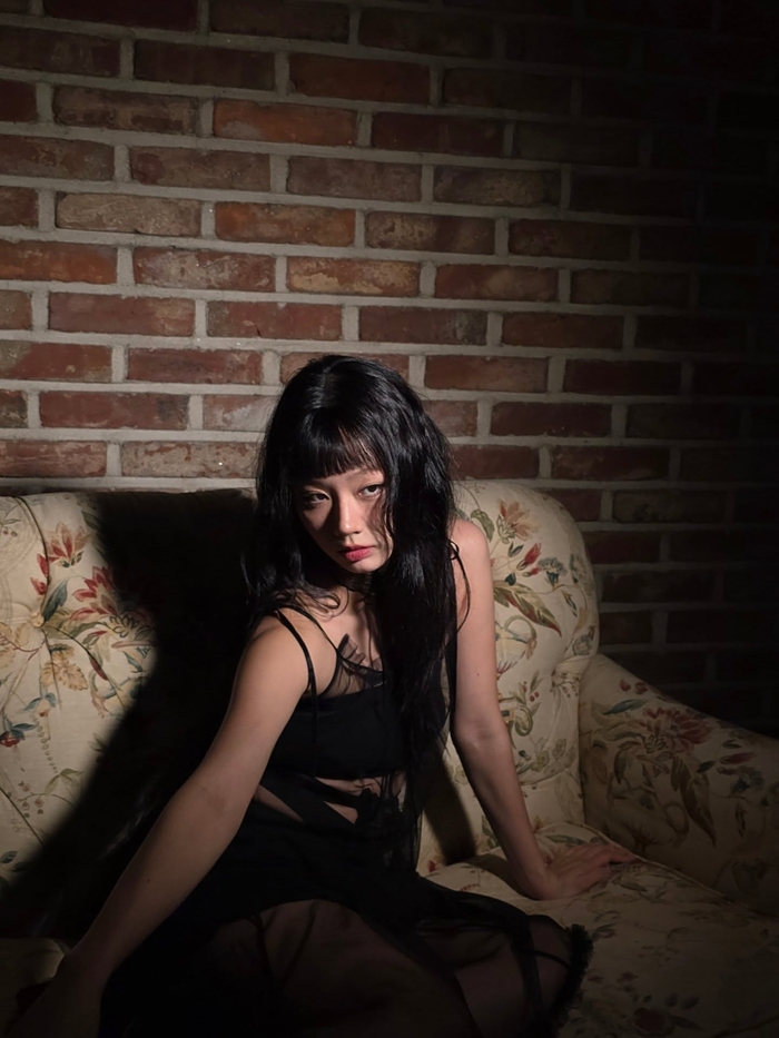 Hyeri posing elegantly on a sofa