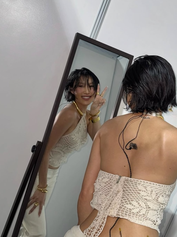 Ekspresi pede Hwasa pose pakai jeans krem dan vest rajut.