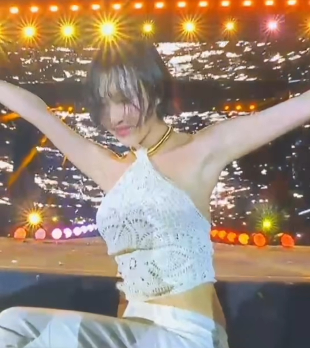 Momen candid Hwasa pamerin gaya effortless pakai jeans krem dan vest rajut.