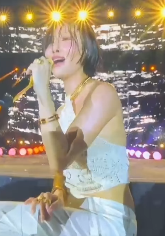 Hwasa pose pakai jeans krem skinny dan vest rajut, nunjukkin harmoni outfit.