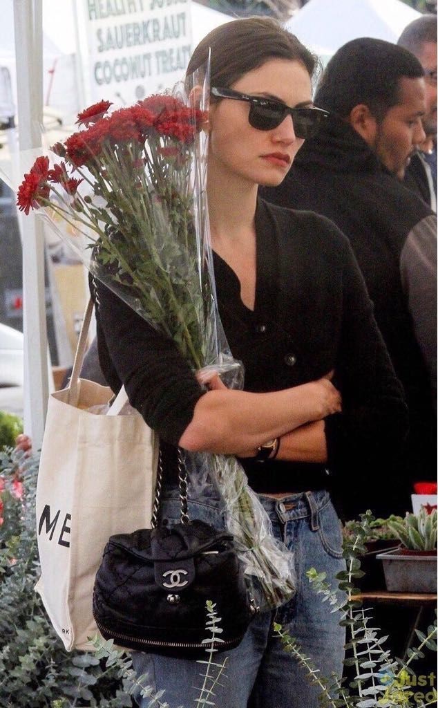 An elegant model posing with a highly sought-after vintage Chanel handbag.