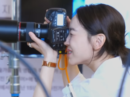 Detail shot of the Cartier watch, highlighting the blue hands and sapphire cabochon.