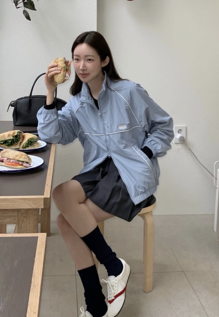 Close-up of the Marithe Francois Girbaud windbreaker, highlighting its high neck and logo detail.